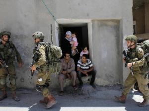 Israeli troops search a Palestinian home in the West Bank