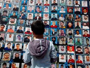 A Palestinian boy looks at pictures of Palestinian political prisoners being held by Israel.